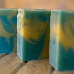 May include: Four bars of handmade soap with a swirl pattern of yellow and blue.