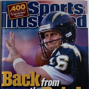 May include: Sports Illustrated magazine cover. A football player in a navy blue helmet and jersey with the number 6 is featured. The cover text reads "Back from the Brink" and "400, It can be done."