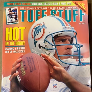 May include: A December 1995 issue of Tuff Stuff, The Nation's Favorite Trading Card Magazine, featuring a close-up of a football player wearing a white and teal jersey with the number 13. The player is holding a brown football and is wearing a white helmet with a teal visor. The magazine cover also features the text "HOT IN THE HOBBY" and "MARINO & RIPKEN FIRE UP COLLECTORS".