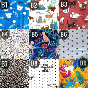 May include: A collection of nine fabric swatches with various patterns. Designs include cats, leopard spots, paw prints, and floral arrangements. Some swatches feature text like "MEOW" and "The Snuggle is Real."