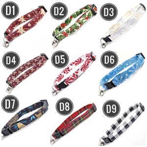K&ouml;nnte beinhalten: Neun Katzenhalsb&auml;nder mit verschiedenen weihnachtlichen Mustern. Designs umfassen Sterne, Stechpalmen, Schneeflocken, Lebkuchenm&auml;nner, Zuckerstangen, Schneeflocken, Paisley, Schottenkaro und B&uuml;ffelkaromuster. Jedes Halsband hat eine schwarze Schnalle und eine kleine silberne Glocke.