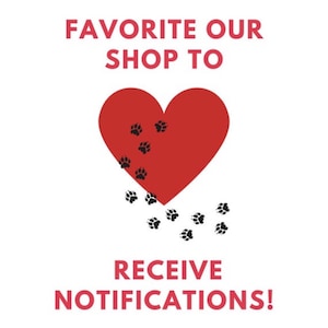 May include: White background with red text and a red heart. The text reads "FAVORITE OUR SHOP TO RECEIVE NOTIFICATIONS!". The heart has black paw prints falling from it, suggesting a pet-related theme.