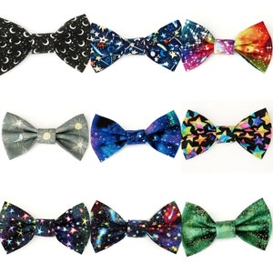 May include: A collection of nine bow ties with celestial and galaxy patterns. The bow ties feature designs with moons, stars, and colorful space scenes. The color palette includes black, blue, green, and rainbow hues.