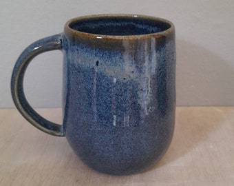 Floating blue handmade ceramic mug.