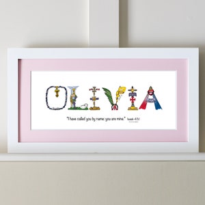 May include: A white framed print with a pink mat. The print features the name "OLIVIA" spelled out in colorful letters with religious imagery. The quote "I have called you by name: you are mine." Isaiah 43:1 is printed below the name.