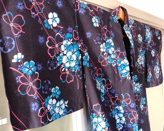 Puede incluir: Un yukata negro con un patrón floral en tonos azules, rosas y blancos. Las flores están dispuestas en un patrón repetitivo en la tela.