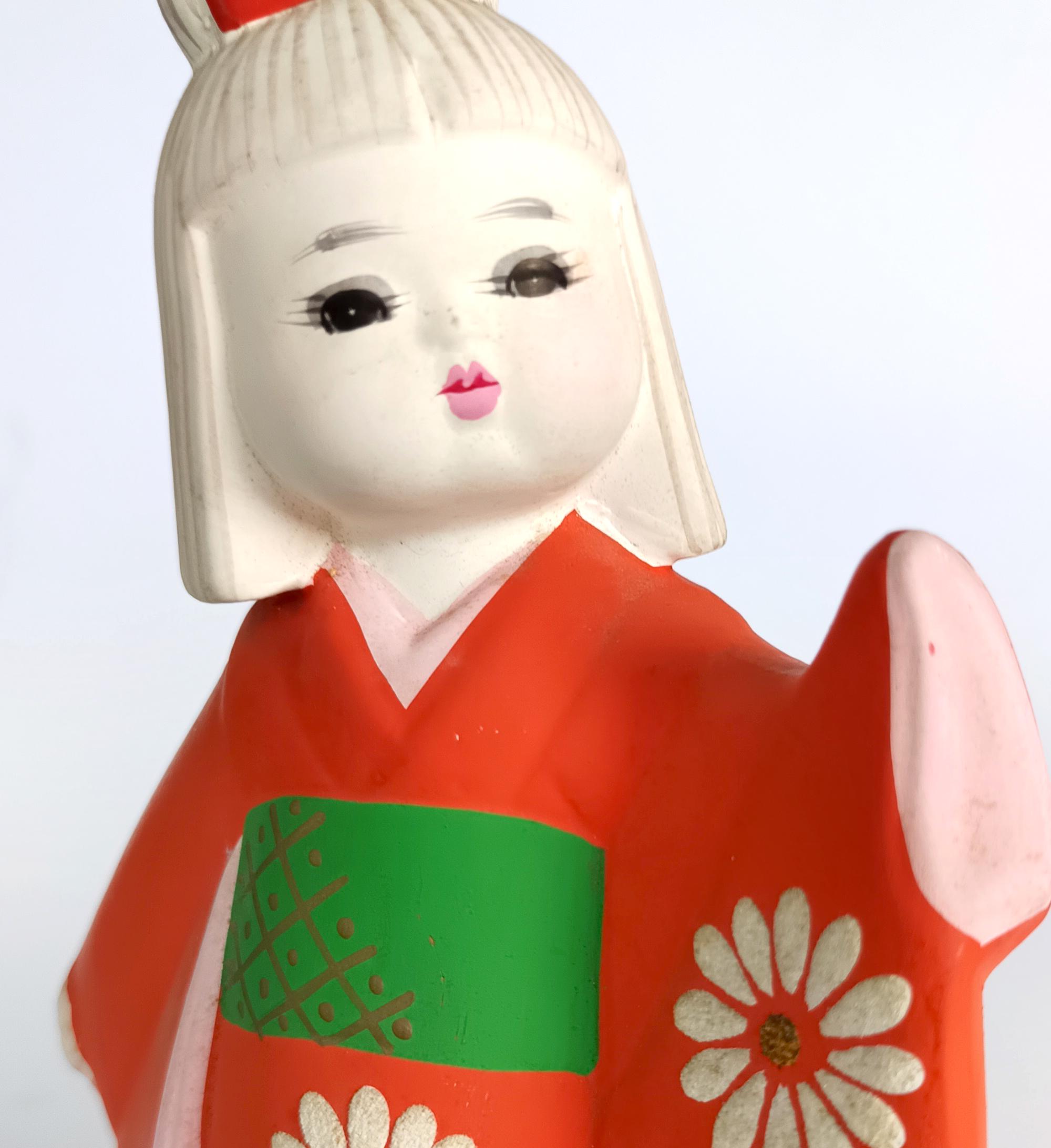 博多人形、日本の伝統的な陶器人形、日本の工芸品、オレンジ色の着物を
