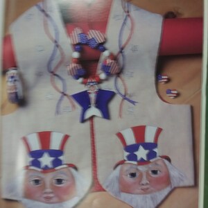 May include: A white vest with red, white, and blue stars and stripes. The vest has two Uncle Sam figures with white beards and red, white, and blue hats. The vest also has a red, white, and blue beaded necklace with stars and stripes.