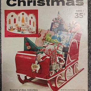 May include: A vintage craft magazine titled Things to Make for Christmas Number 2, featuring a red wooden sled filled with wrapped gifts and a toy clown. The cover displays a cardboard cathedral project and text detailing instructions for holiday crafts.