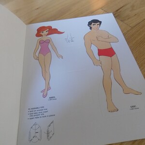 May include: A paper doll set featuring Ariel and Eric from the Disney movie The Little Mermaid. The dolls are printed on white paper and are ready to be cut out and assembled.