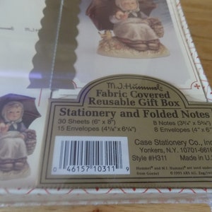 May include: A fabric-covered, reusable gift box for stationery and folded notes. The box includes 30 sheets (6" x 8"), 15 envelopes (4 1/8" x 6 1/4"), 8 notes (3 3/4" x 5 3/4"), and 8 envelopes (4" x 6"). The box features a Hummel figurine.