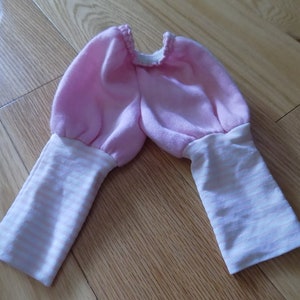 May include: Pink baby pants with white and pink striped cuffs.