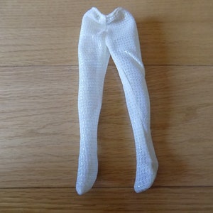 Puede incluir: Mallas blancas brillantes para una muñeca. Las mallas están hechas de una tela transparente con un acabado brillante.