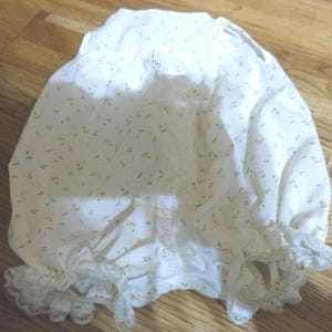 Puede incluir: Bombachos de algodón blanco con estampado floral y ribete de encaje.