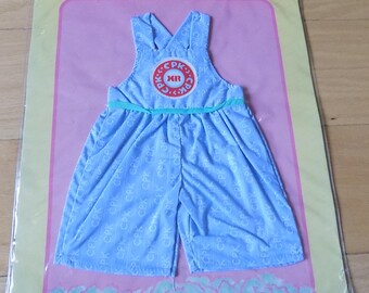 Puede incluir: Un atuendo azul Cabbage Patch Kids Deluxe Fashions con un patrón blanco y azul y un cinturón verde. El atuendo tiene un gran logotipo de Cabbage Patch Kids en la parte delantera.