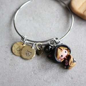 Pulsera rígida de acero inoxidable con muñeco de gato de fimo y dijes de latón grabados – Hecha a mano