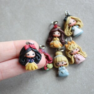 May include: A set of six handmade polymer clay charms featuring Disney princesses. Each charm is approximately 5 cm tall and features a different princess in a colourful dress. The charms are perfect for adding a touch of whimsy to your jewellery or crafts.