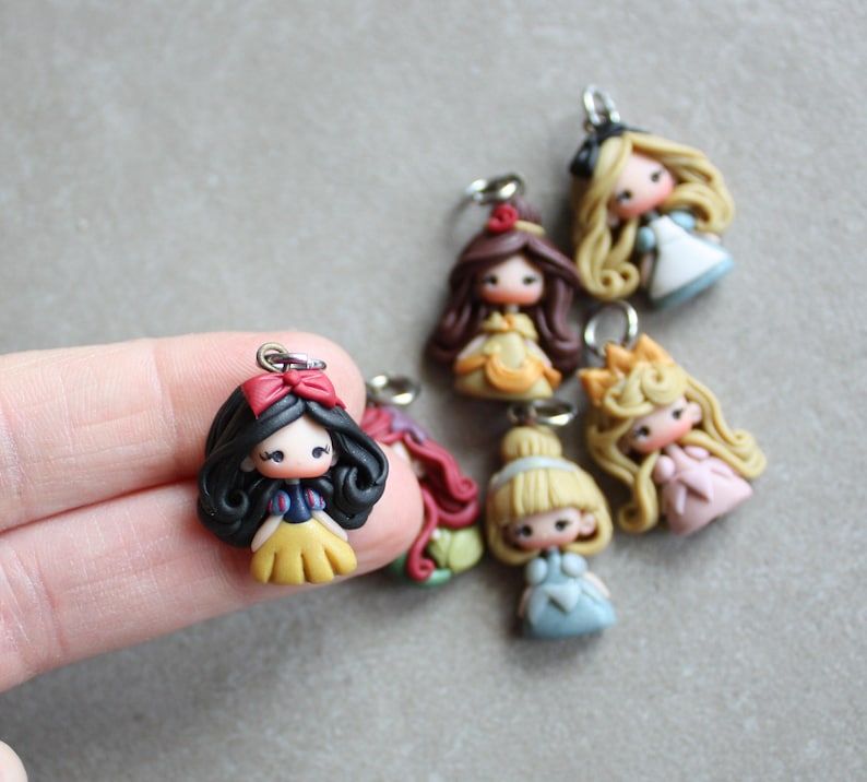 May include: A set of six handmade polymer clay charms featuring Disney princesses. Each charm is approximately 5 cm tall and features a different princess in a colourful dress. The charms are perfect for adding a touch of whimsy to your jewellery or crafts.