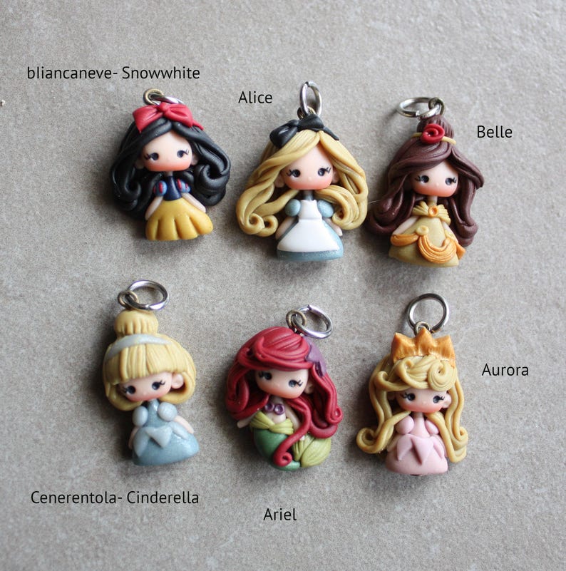 May include: Six handmade polymer clay charms featuring Disney princesses. The charms are Snow White, Alice, Belle, Cinderella, Ariel, and Aurora. Each charm has a silver loop for attaching to a necklace or bracelet.