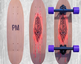 Könnte beinhalten: Drei Holz-Skateboards. Eines ist leer mit den Buchstaben "PM". Die anderen beiden haben ein Feder- und Augendesign in Rot und Schwarz. Eines hat lila Rollen und schwarze Achsen.