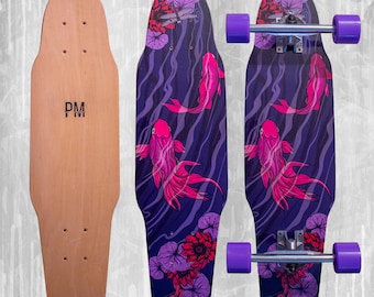 Könnte beinhalten: Ein Holz-Skateboard mit natürlichem Finish und den Initialen "PM" auf der Unterseite. Zwei Skateboards zeigen ein lila-blaues Design mit rosa Koi-Fischen und floralen Akzenten. Die Skateboards haben lila Rollen.
