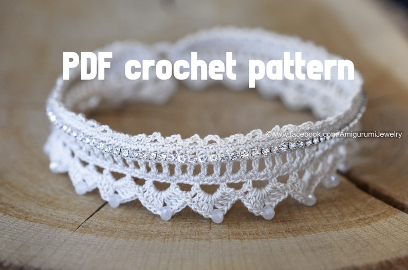 Puede incluir: Un collar gargantilla de crochet blanco con una fila de diamantes de imitaci&oacute;n y cuentas blancas. El collar est&aacute; sobre una superficie de madera. Patr&oacute;n de crochet PDF.
