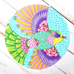 May include: A colorful, circular illustration of a bird in flight. The bird features a yellow beak, green head, and a body with pink, teal, and purple accents. Its wings are spread, showcasing a vibrant array of colors including pink, yellow, and purple. The background is light blue with raindrop details.