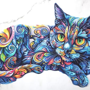 May include: A colorful illustration of a cat with intricate patterns. The cat's fur is a mix of blues, greens, yellows, and reds, with swirling designs. The cat has green eyes and is lying down on a white surface.