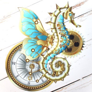 Op de afbeelding: Een gouden en blauwe steampunk-zeepaardje met een kompas en tandwielen. Het zeepaardje heeft een vlinder vleugel ontwerp en bevindt zich op een witte houten achtergrond.