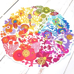 May include: A colorful circular design featuring a rainbow of colors, including red, orange, yellow, green, blue, indigo, and violet. The design is filled with intricate patterns of flowers, butterflies, and other nature-inspired elements.