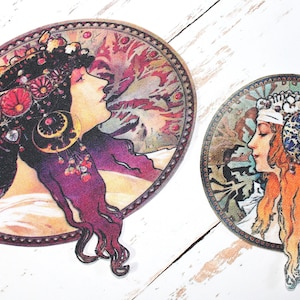 May include: Two oval stickers in the Art Nouveau style, depicting women's profiles. One has dark hair with red flowers and purple accents. The other has red hair and a blue and white headpiece. Both have decorative borders.