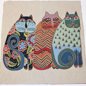 Op de afbeelding: Drie gestileerde katten met kleurrijke patronen en ontwerpen. De kat links is zwart met blauwe, groene en rode bloemenpatronen. De kat in het midden is oranje en bruin met een zigzagpatroon. De kat rechts is blauw en groen met een driehoekig patroon.