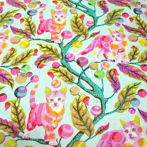 K&ouml;nnte beinhalten: Ein Stoff mit einem sich wiederholenden Muster aus rosa und orangefarbenen Katzen, die auf t&uuml;rkisfarbenen &Auml;sten mit bunten Beeren und Bl&auml;ttern sitzen. Die Katzen haben gelbe Ohren und sind vor einem hellblauen Hintergrund platziert.
