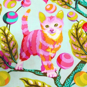 K&ouml;nnte beinhalten: Ein farbenfroher Stoff mit einer stilisierten Katze mit rosa, orangefarbenen und wei&szlig;en Streifen. Die Katze ist vor einem hellblauen Hintergrund mit skurrilen, farbenfrohen Kugeln und Bl&auml;ttern platziert. Das Design hat eine verspielte, k&uuml;nstlerische &Auml;sthetik.