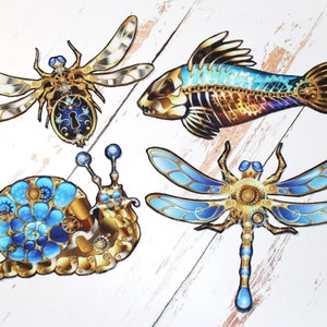 May include: Four decorative, intricately detailed, steampunk-style animal figures with gold and blue accents. A dragonfly, a snail, a fish, and a bee.