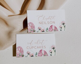 May include: Two white cards with pink watercolor eggs and green leaves. The top card says "Elizabeth Neilson" and the bottom card says "red velvet cupcakes".