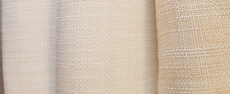 May include: Three different types of white fabric with varying textures. The fabric on the left is smooth, the middle fabric has a subtle texture, and the fabric on the right has a more pronounced texture.