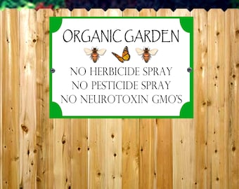 May include: Green sign with white text and images of bees and a butterfly. The sign reads "Organic Garden" and "No Herbicide Spray, No Pesticide Spray, No Neurotoxin GMO's".
