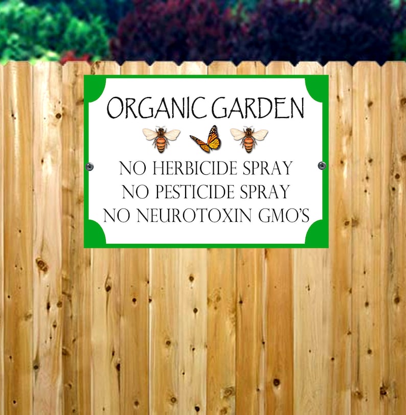 Puede incluir: Un cartel verde con texto blanco e im&aacute;genes de abejas y una mariposa. El cartel dice "Jard&iacute;n org&aacute;nico" y "No se permite el uso de herbicidas, pesticidas ni neurotoxinas OGM".