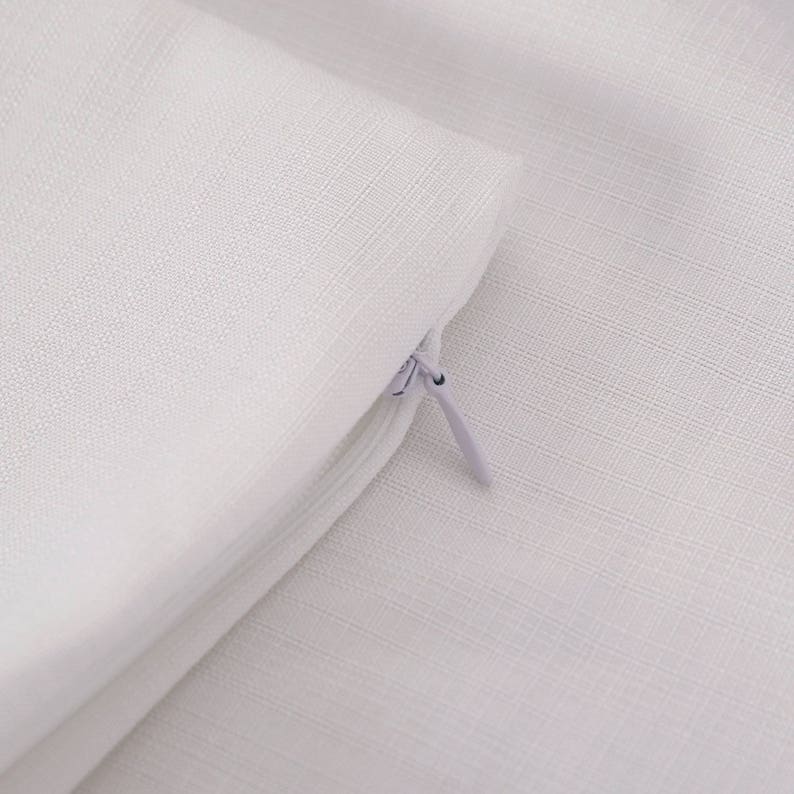 May include: A white pillow cover with a zipper closure. The cover is made of a soft, textured fabric.