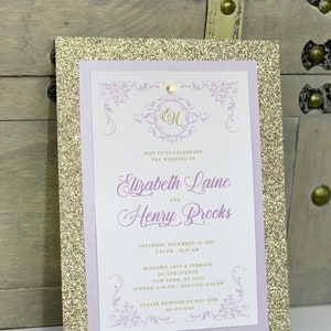 May include: Gold glitter wedding invitation with a purple border. The invitation features the names Elizabeth Laine and Henry Brooks, the date December 14, 2012, and the location Midtown Loft & Terrace, 247 5th Avenue, New York, NY 10016.