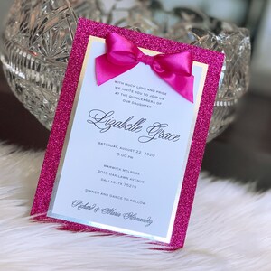 May include: Pink glitter card with a white border and a pink bow. The card has the text "WITH MUCH LOVE AND PRIDE WE INVITE YOU TO JOIN US AT THE QUINCEA&Ntilde;ERA OF OUR DAUGHTER Bizabelle Grace SATURDAY, AUGUST 22, 2020 5:00 PM WARWICK MELROSE 3015 OAK LAWN AVENUE DALLAS, TX 75219 DINNER AND DANCE TO FOLLOW Richard & Maria Hernandez".