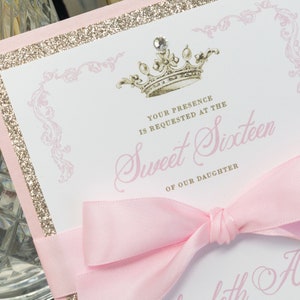 Może przedstawiać: R&oacute;żowe i złote zaproszenie z koroną i tekstem "Proszę o obecność na Sweet Sixteen naszej c&oacute;rki".