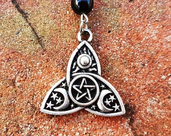 May include: Silver pendant necklace with a triple moon and pentagram charm. The charm is a silver triquetra with a pentagram in the center and three crescent moons with stars on each side. The necklace has a black bead.
