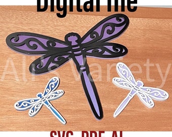 May include: Digital file download of three dragonfly SVG cut files. The largest dragonfly is purple with black outlines. The two smaller dragonflies are white with blue and white outlines. The text "SVG, PDF, AI" is at the bottom of the image.