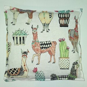 Peut inclure: Taie d'oreiller blanche avec un motif répété de lamas et de cactus. Les lamas sont bruns, blancs et noirs avec des accents colorés. Les cactus sont verts avec des fleurs rouges et sont dans des pots à rayures noires et blanches ou des pots bruns avec des pois blancs.