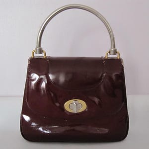 Bolso GUCCI vintage de charol burdeos con asa superior, cierre de latón, plateado y dorado, años 70