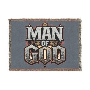 May include: A grey woven throw blanket featuring the text "MAN OF GOD" in a distressed style. The blanket has a fringed edge and a lion graphic. The text is in white, orange, and black.