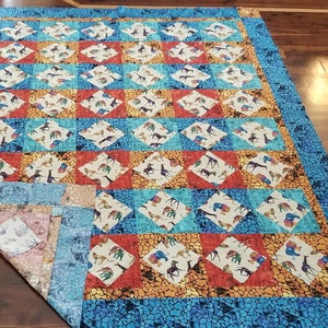 Twin unfinished quilt top in African Animals on point. Gender neutral. Red, blue, gold, turquoise.  63.5 x 80.5 inches