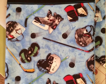 Hockey Pillowcase,  sky blue background with hockey helmets, pucks and sticks.   Black and sky blue trim at opening.